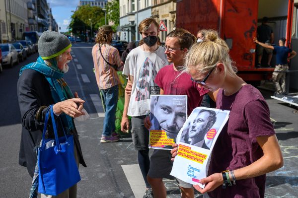 Alter Mann diskutiert mit Klimaaktivisten während eines Protests vor der FDP-Zentrale für das 9-Euro-Ticket
