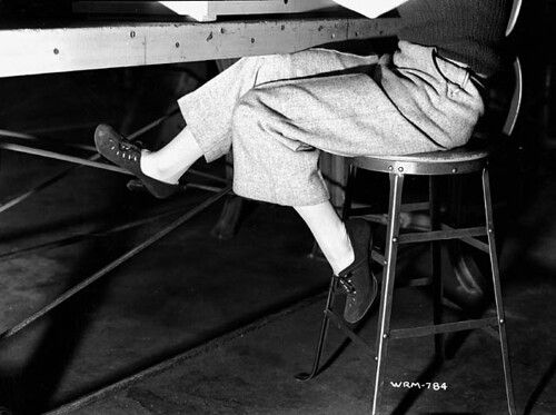 Footwear worn by a woman munitions worker as she sits at a table in the John Inglis Co. Bren gun plant / Chaussures port