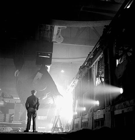 Worker observes ladle pouring molten steel at the Stelco Steel Company of Canada's open-hearth furnaces, Hamilton, Ontar