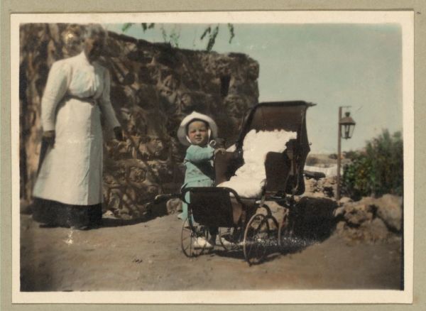 Vintage Picture of a Child Standing Outside, Along the Side of, a Baby Carriage Buggy