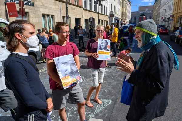 Alter Mann diskutiert mit Klimaaktivisten während eines Protests vor der FDP-Zentrale für das 9-Euro-Ticket