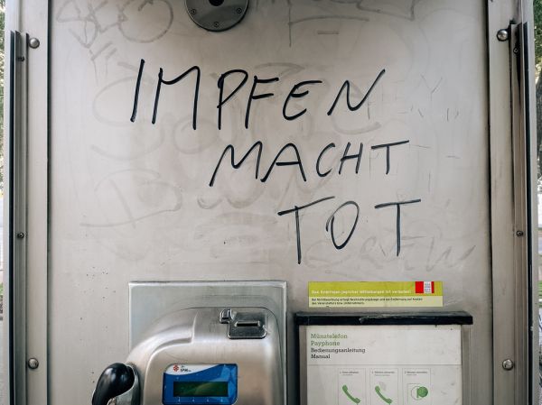 Botschaft gegen Corona-Schutzimpfung in einer Telefonzelle mit Text 'Impfen macht tot'