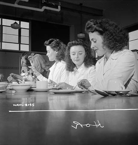Women munitions workers enjoying their half-hour lunch in the Dominion Arsenals Ltd. plant cafeteria. / Lors de la demi-