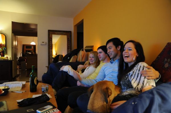 Rosie, the dog, continues to request a seat on the couch, while everyone enjoys the conversation, Dani laughs, watching 