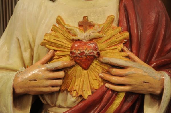 Christ's hands gesturing towards his heart, with glow, thorns, cross - no matter how much someone hurts you, return only