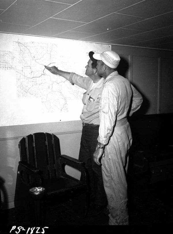 1958. PBY pilots Vanaken and Skeem with spray block map. Spruce budworm control project. Baker airstrip, Oregon.